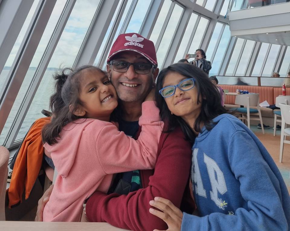 Muks and daughters Riya is wearing blue eye glasses and smiling at the camera